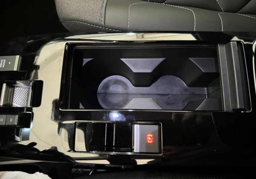 Gros plan sur la console centrale noire de la Citroën C4 PureTech 130 EAT8 Shine avec frein à main électrique activé.