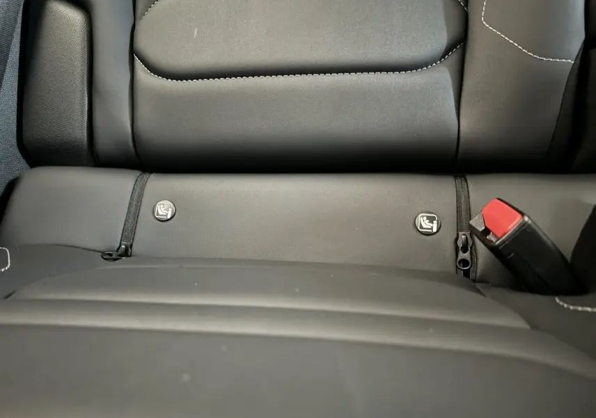 Gros plan sur la banquette arrière noire de la Citroën C4 PureTech 130 EAT8 Shine avec fixation Isofix et ceinture rouge.