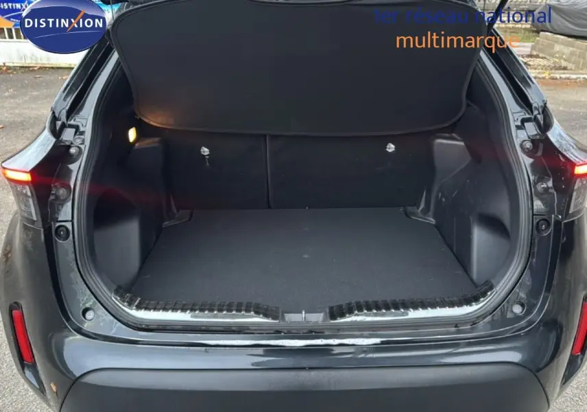 Coffre ouvert en vue arrière d'une Toyota Yaris Cross 116h Design noire 2023, montrant l'espace de chargement vide.