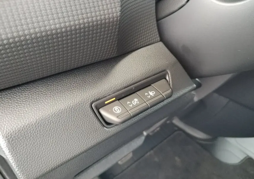 Gros plan sur les boutons de réglage du tableau de bord noir du Nissan Primastar blanc, version 2025.