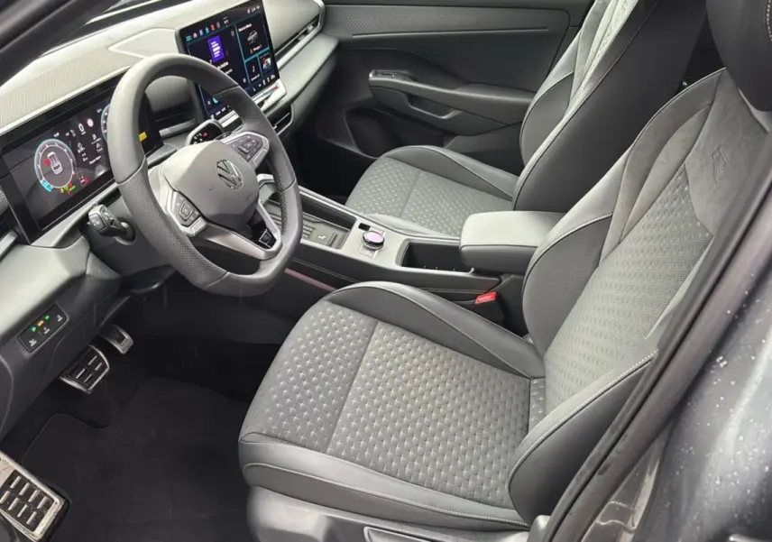 Vue intérieure côté conducteur du Volkswagen T-Roc gris loup 2026, avec sièges tissu R-Line et tableau de bord digital.