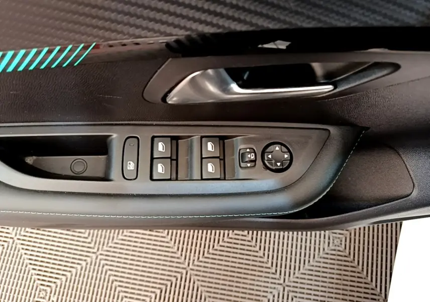Vue rapprochée de la porte avant gauche de la Peugeot 208 blanche, montrant les commandes des vitres et rétroviseurs.