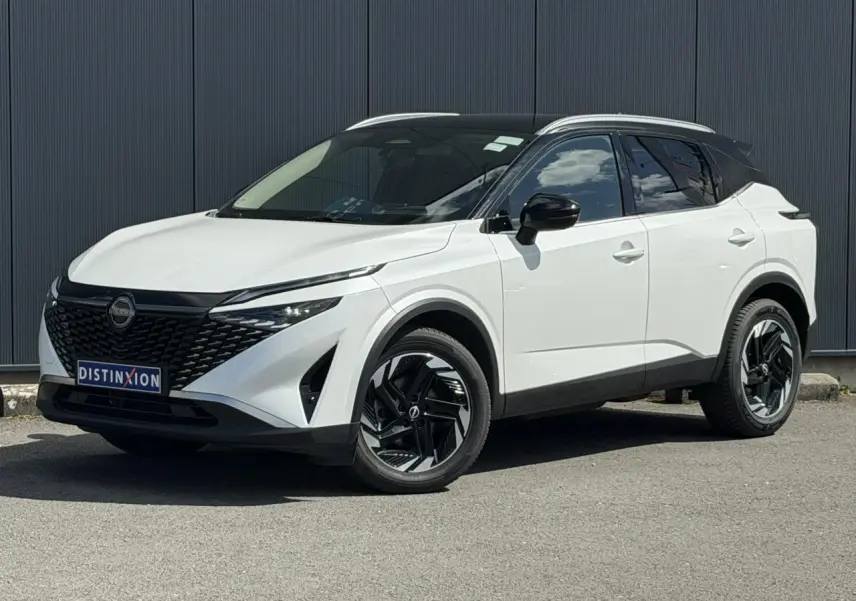 Nissan Qashqai blanc nacré avec toit noir, vu en 3/4 avant droit, jantes alliage noires et calandre distinctive.