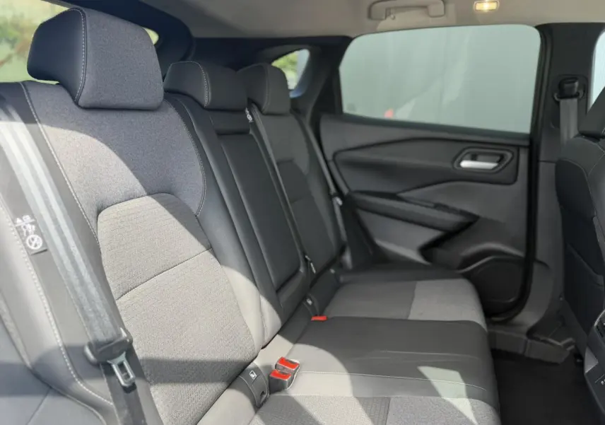Vue latérale droite de l'habitacle arrière du Nissan Qashqai 2025, sièges mixte tissu et TEP noirs.