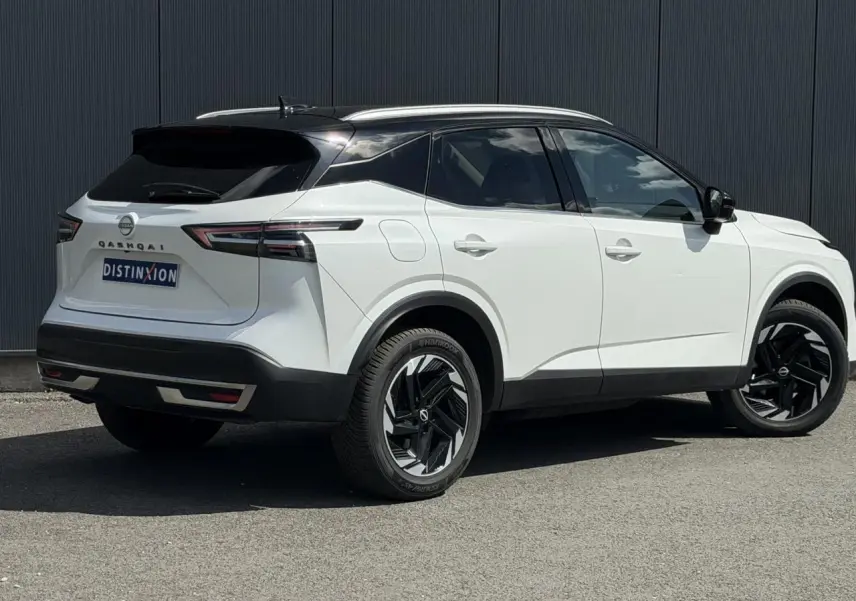 Vue 3/4 arrière droite du Nissan Qashqai blanc nacré avec toit noir et jantes alliage noires.