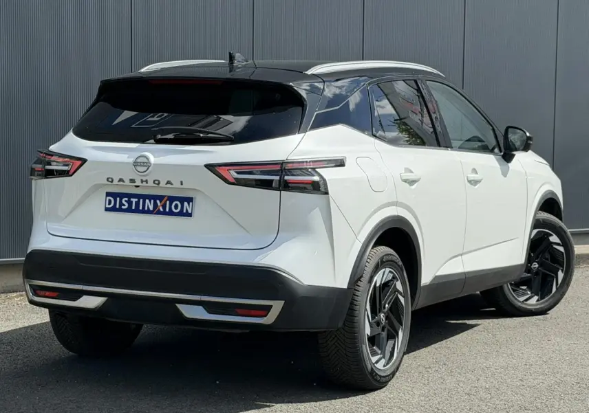 Vue 3/4 arrière droite du Nissan Qashqai blanc nacré avec toit noir et jantes alliage 18 pouces.