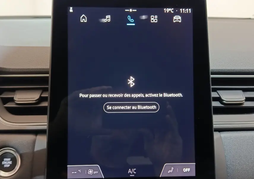 Écran tactile central affichant la connexion Bluetooth dans l’habitacle du Renault Captur blanc techno E-Tech 2025.