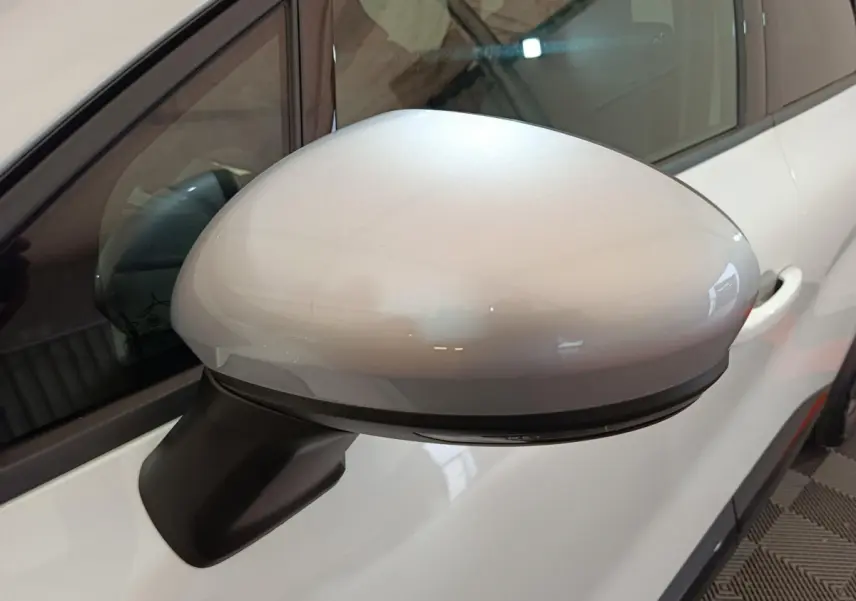 Rétroviseur droit blanc brillant du Renault Captur 2025 techno E-Tech full hybrid, avec clignotant intégré visible.