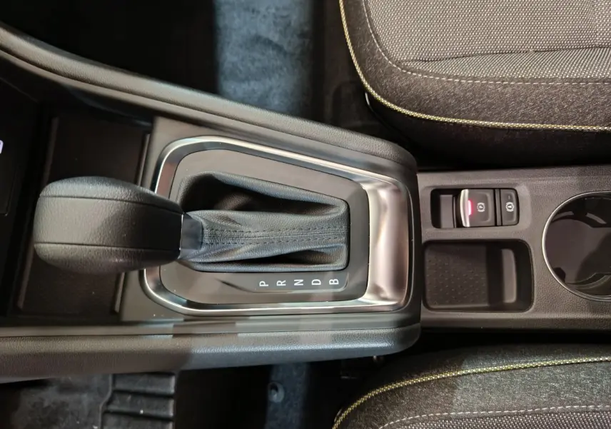 Vue rapprochée de la boîte automatique noire et du frein à main électrique dans l'habitacle du Renault Captur blanc 2025.