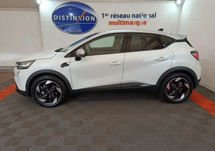 Profil côté gauche d'un Renault Captur blanc 2025 techno E-Tech full hybrid avec jantes noires et toit noir.