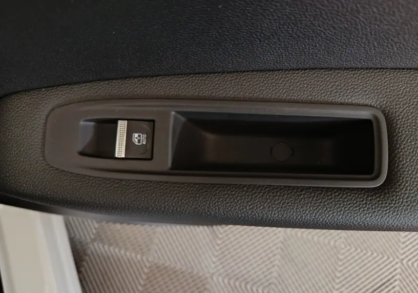 Gros plan sur le bouton de commande de vitre électrique côté conducteur du Renault Captur blanc 2025.