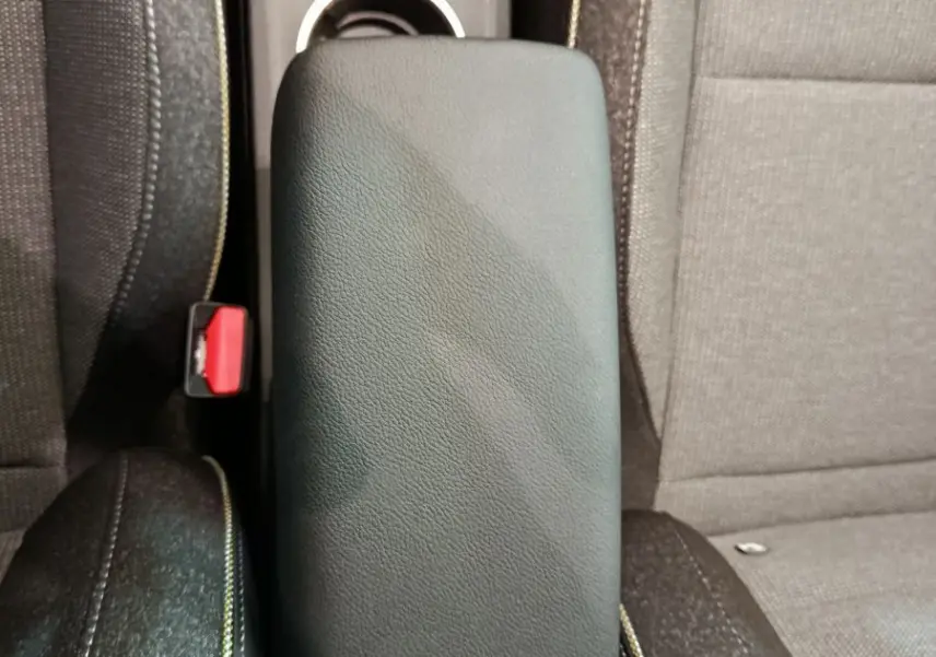 Vue plongeante sur l'accoudoir central en cuir synthétique noir entre les sièges avant du Renault Captur blanc 2025.