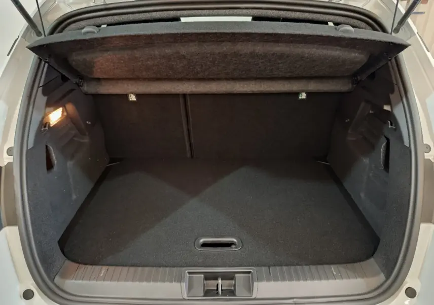 Coffre ouvert vu de l'arrière d'un Renault Captur blanc 2025, montrant un espace de rangement noir et propre.