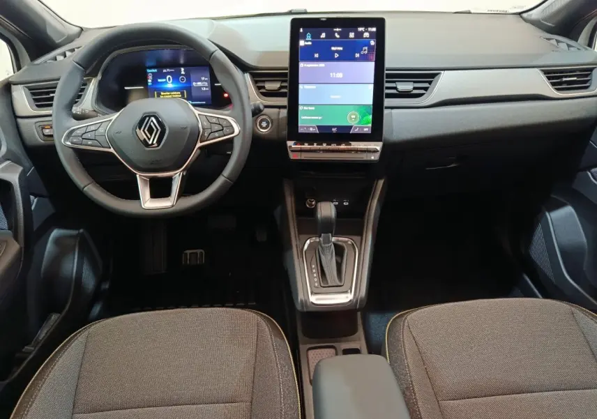 Intérieur du Renault Captur Techno E-Tech 2025, vue frontale du tableau de bord avec écran tactile vertical et volant multifonctions.