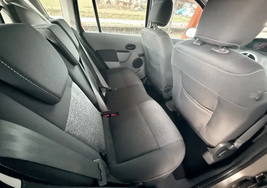 Vue intérieure montrant les sièges arrière en tissu gris noir de la Renault Modus beige, côté droit ouvert.