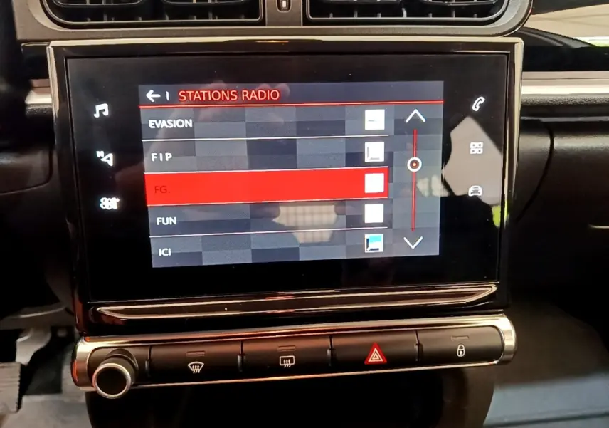 Vue rapprochée de l’écran tactile central du tableau de bord de la Citroën C3 2021, affichant les stations radio.