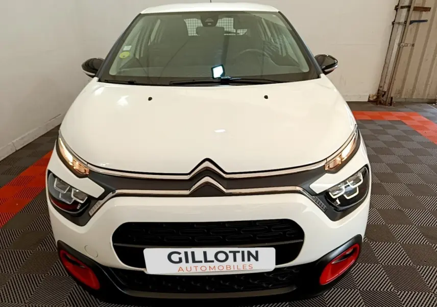 Vue avant d'une Citroën C3 blanche 2021 avec phares LED et détails rouges sur le pare-chocs.