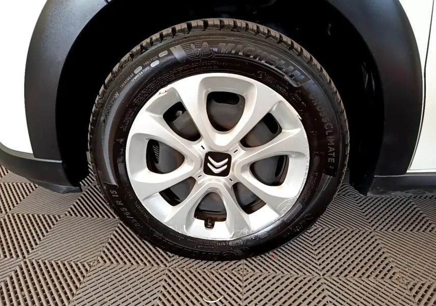 Gros plan sur la roue avant droite blanche d'une Citroën C3 2021 avec jante en alliage et logo Citroën au centre.