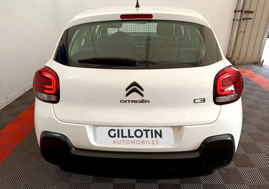 Vue arrière d'une Citroën C3 blanche 2021 avec feux arrière LED et pare-chocs noir dans un garage.