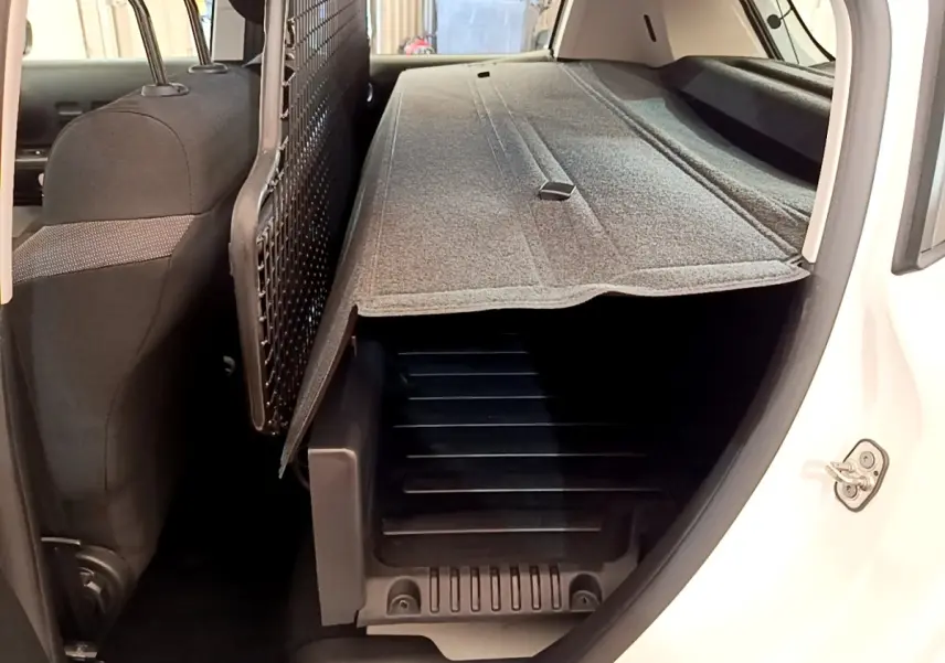 Vue intérieure arrière côté droit du coffre d'une Citroën C3 blanche 2021 avec cache-bagages déployé.