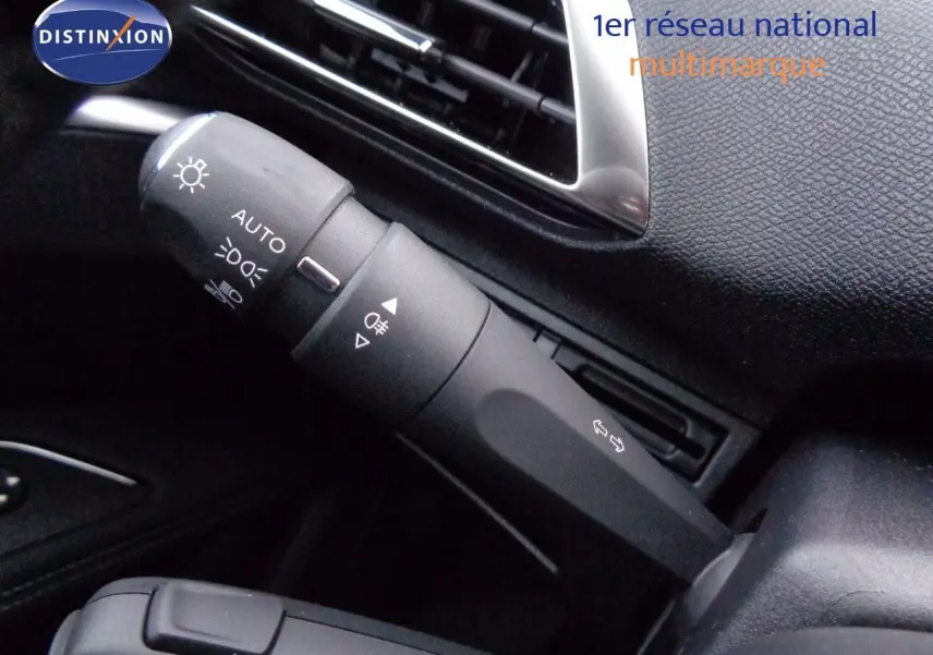 Gros plan sur la commande des feux et clignotants dans l'habitacle noir du Peugeot 3008 2023.