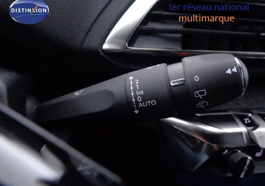 Gros plan sur la commande d'essuie-glace à gauche du volant dans l'habitacle d'un Peugeot 3008 bleu 2023.