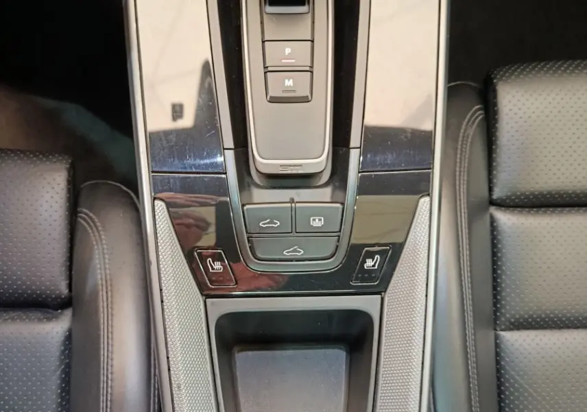 Vue plongeante sur la console centrale noire du Porsche 911 Carrera 4S 2019 avec levier de vitesse automatique et sièges cuir perforé.