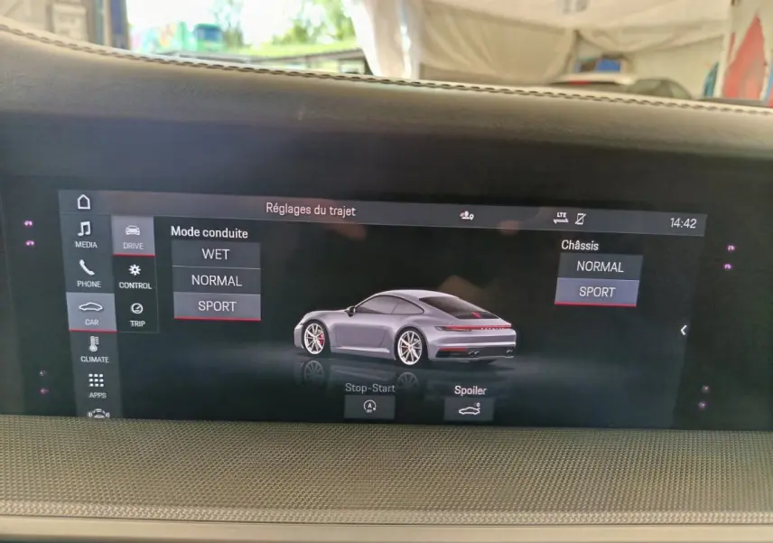 Écran tactile intérieur affichant une Porsche 911 Carrera 4S Coupé gris foncé vue de 3/4 arrière en mode sport.