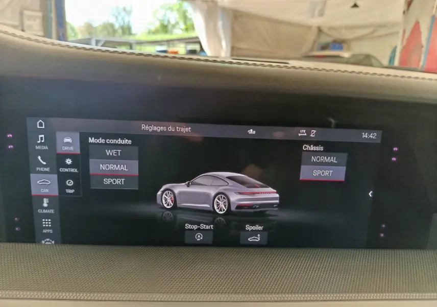 Écran tactile intérieur affichant une Porsche 911 Carrera 4S Coupé gris foncé en vue 3/4 arrière.