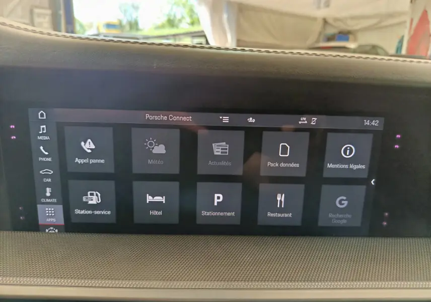 Écran tactile central affichant le menu Porsche Connect dans l'habitacle clair d'une Porsche 911 Carrera 4S Coupé 2019.
