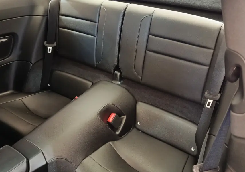 Vue rapprochée des sièges arrière en cuir noir de la Porsche 911 Carrera 4S Coupé 2019, avec ceintures de sécurité visibles.