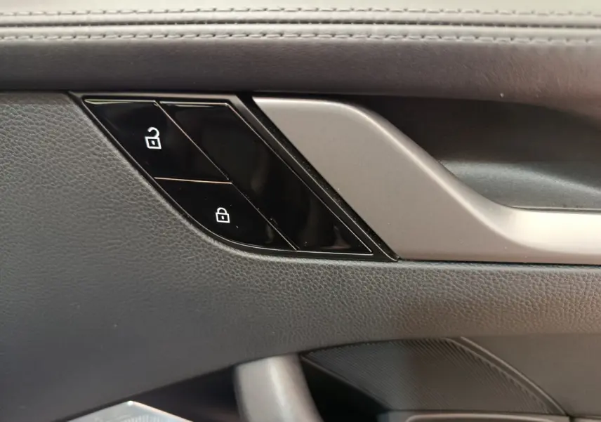 Gros plan sur la commande de verrouillage des portes côté conducteur, garniture cuir noire de la Porsche 911 Carrera 4S 2019.