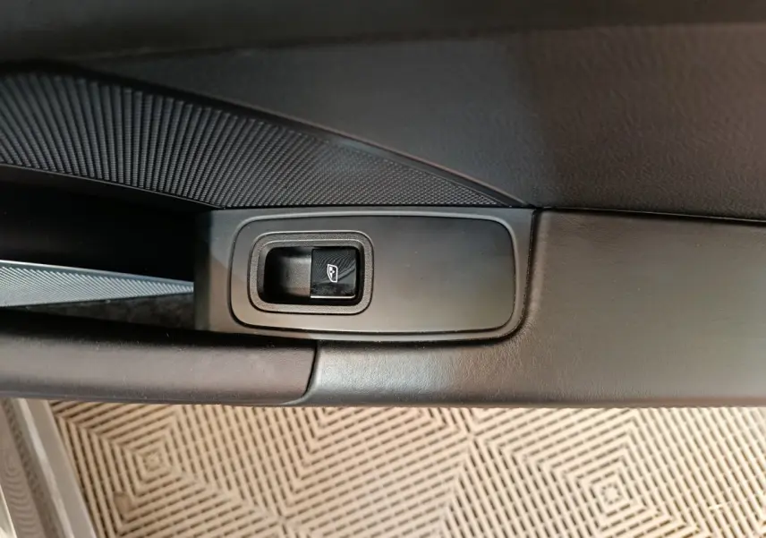 Gros plan sur le bouton de lève-vitre électrique côté gauche de la porte intérieure noire d'une Porsche 911 Carrera 4S Coupé 2019.