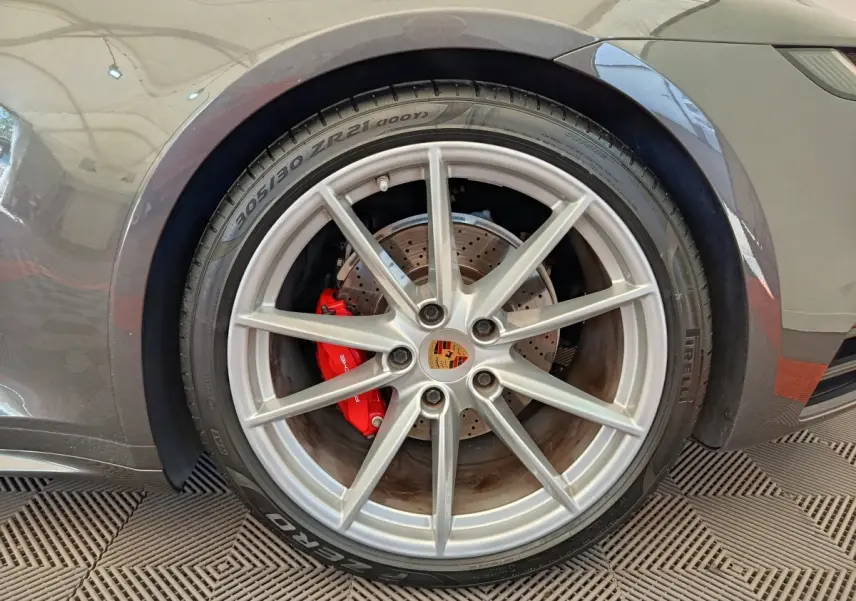 Gros plan sur la roue arrière droite grise d'une Porsche 911 Carrera 4S avec étrier de frein rouge visible.