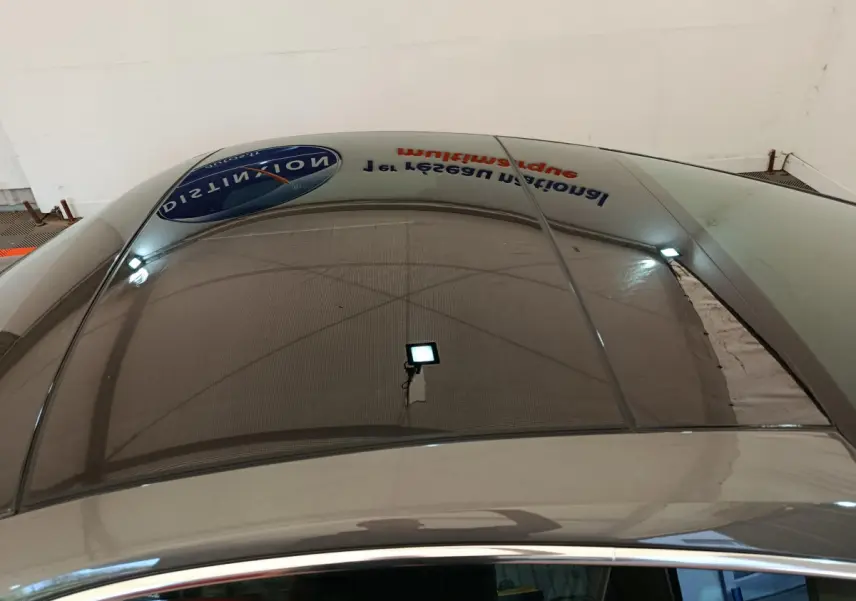 Toit panoramique en verre du Porsche 911 Carrera 4S Coupé gris foncé, vue plongeante sur l'habitacle et le reflet du plafond.