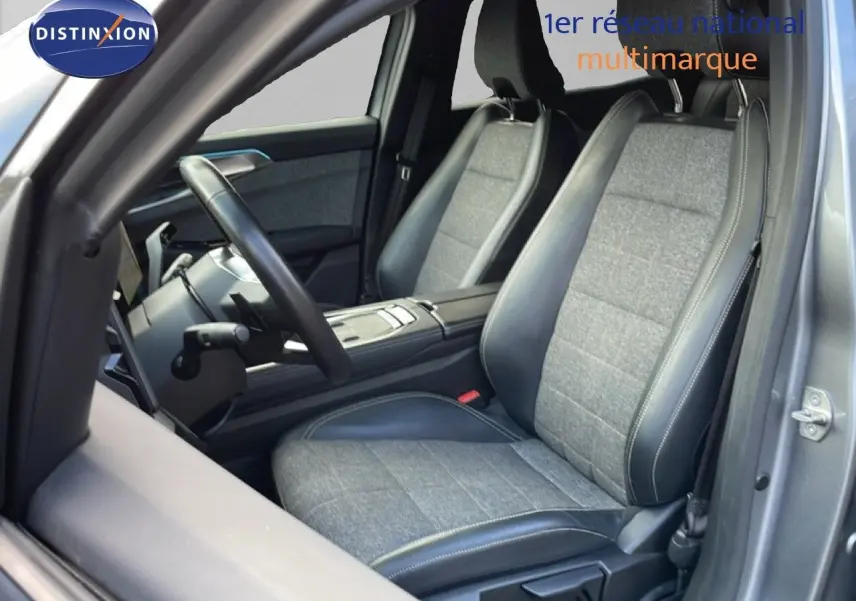 Vue intérieure côté conducteur du Renault Espace 2024, sièges bi-matière tissu gris et cuir noir avec surpiqûres contrastées.