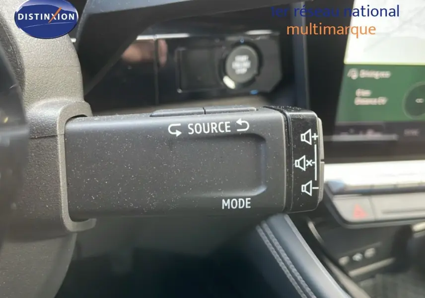 Gros plan sur la commande audio au volant du Renault Espace gris schiste, avec tableau de bord et écran tactile en arrière-plan.