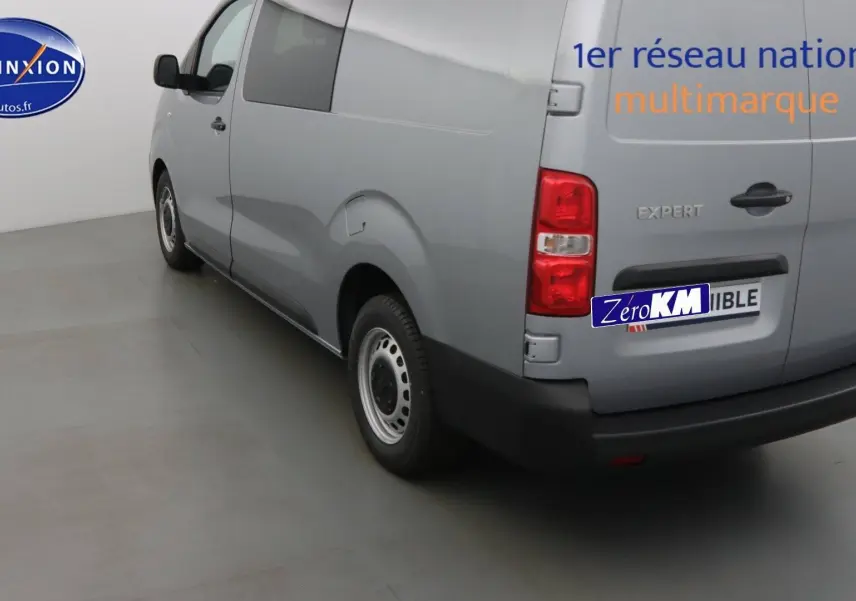 Vue 3/4 arrière droite d'un Peugeot Expert Long gris Artense métallisé avec logo et hayon fermé dans un studio.