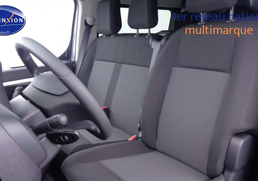 Vue intérieure côté conducteur du Peugeot Expert Long 2023, sièges tissu gris noir et volant simple noir.