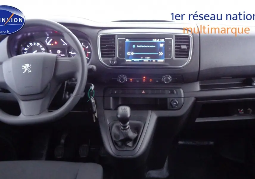 Intérieur du Peugeot Expert Long 2023, tableau de bord et volant gris avec boîte manuelle visible au centre.