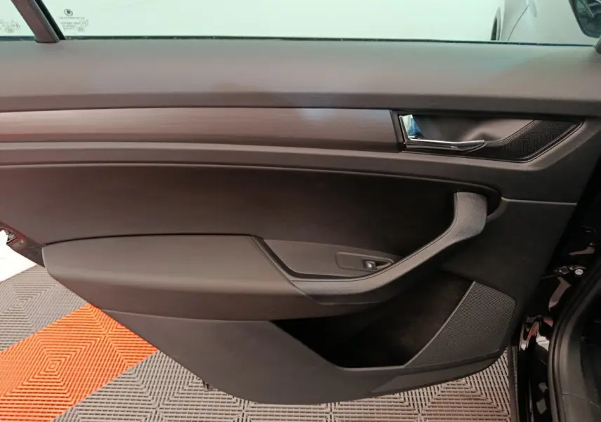 Porte intérieure côté gauche noire du Skoda Kodiaq 2021, avec poignée argentée et commande de lève-vitre.