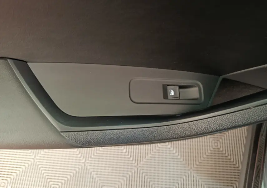 Détail de la commande de verrouillage des portes sur la portière intérieure côté droit d’un Skoda Kodiaq noir.