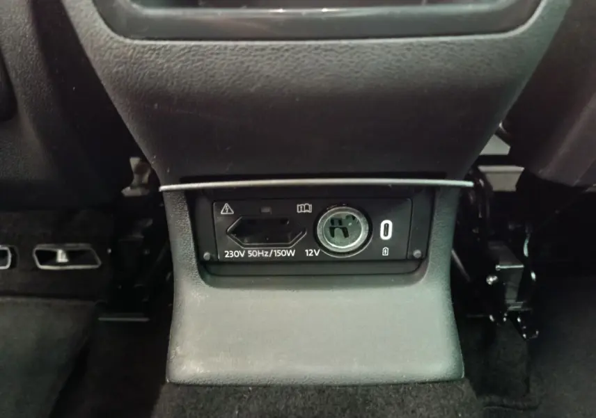 Prise 230V et 12V en gros plan sous la console centrale arrière du Skoda Kodiaq noir 2021.