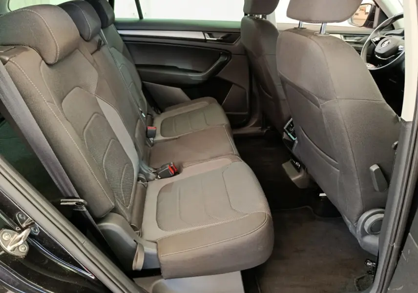Vue côté gauche de l'habitacle arrière noir du Skoda Kodiaq 2021 avec banquette tissu et sièges individuels à l'avant.