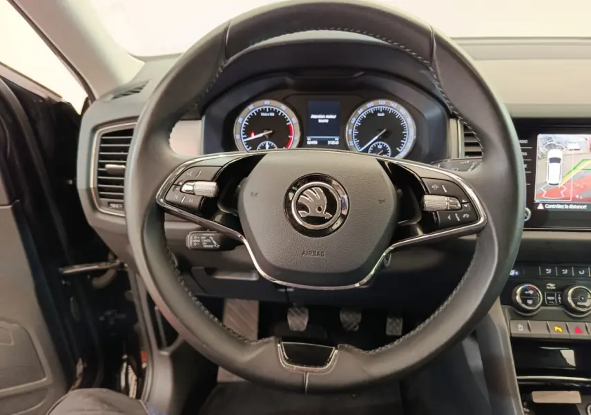 Vue rapprochée du volant cuir noir de la Skoda Kodiaq 2021 avec tableau de bord et écran tactile affichant la caméra de recul.