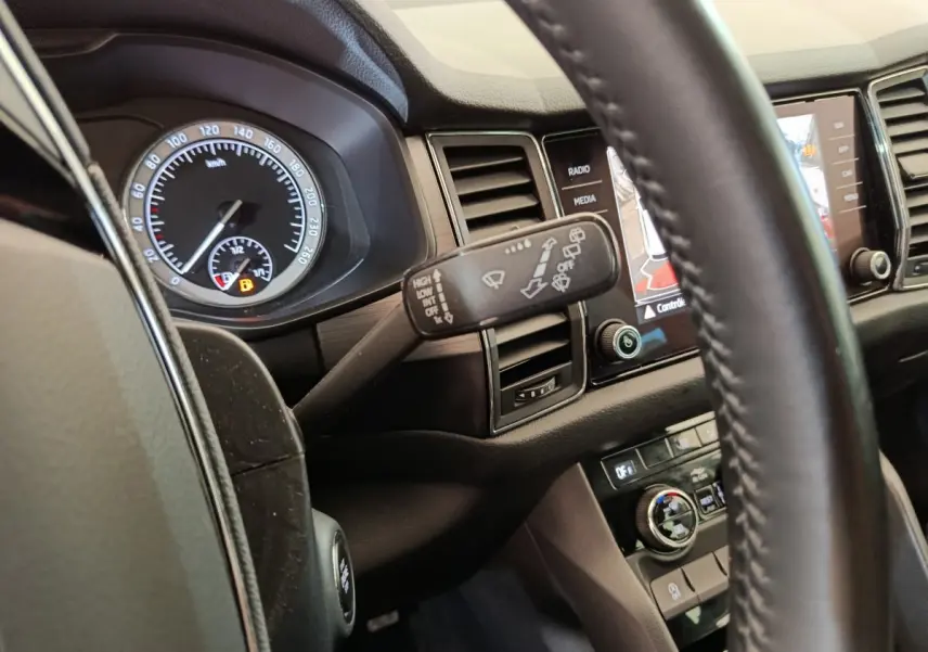 Intérieur du Skoda Kodiaq noir 2021, vue rapprochée du tableau de bord côté conducteur avec commandes et écran tactile.