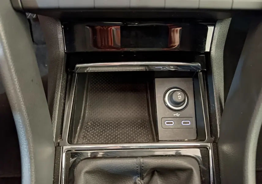 Gros plan sur la console centrale noire du Skoda Kodiaq 2021 avec prise 12V et ports USB visibles