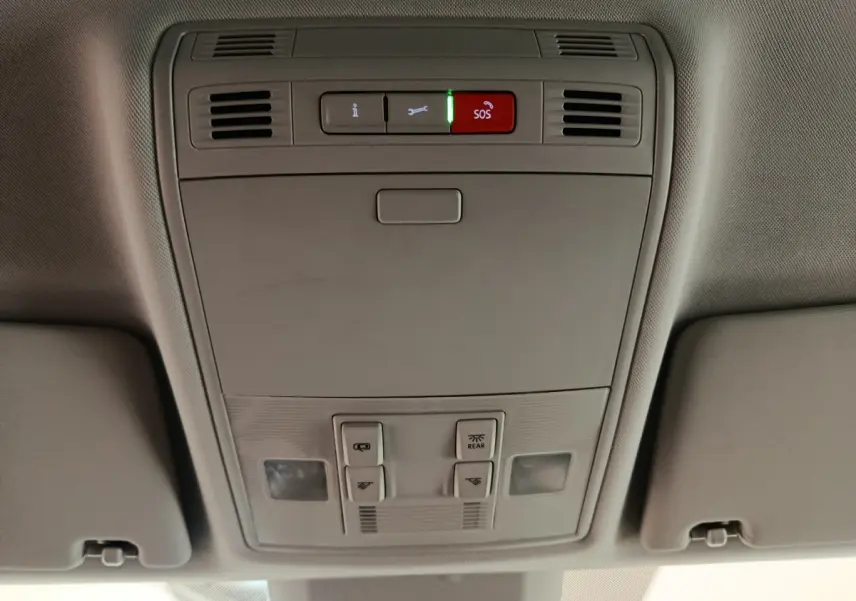 Vue en contre-plongée du panneau de commande de toit gris clair avec bouton SOS rouge dans un Skoda Kodiaq noir 2021
