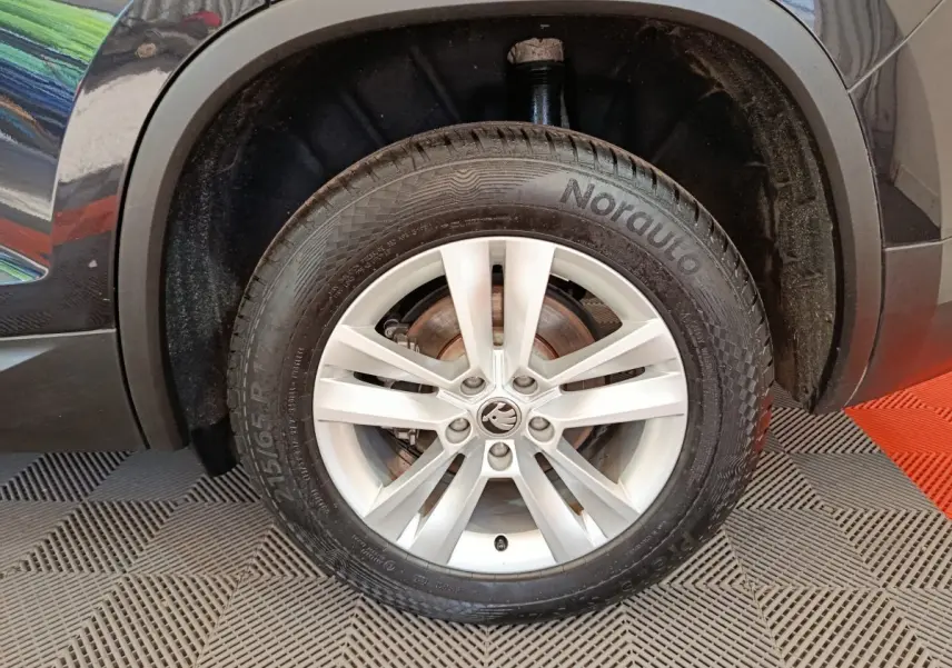 Gros plan sur la roue avant droite noire d'un Skoda Kodiaq 2021 avec jante argentée à 5 doubles branches.