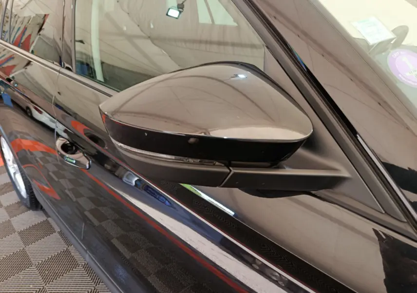 Rétroviseur côté gauche noir brillant du Skoda Kodiaq 2021, vue rapprochée sur la portière et la poignée.